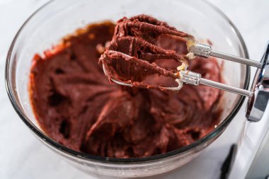 Kırmızı kadife kek ve krem peynir jöleli kek yapmak için büyük bir bardakta karıştırma malzemesi..