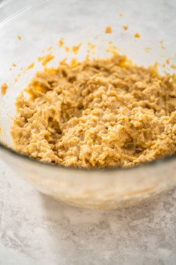 Büyük bir bardaktaki malzemeleri mutfak mikseriyle karıştırıp çikolatalı kurabiyeleri naneli cipsle pişirmek..