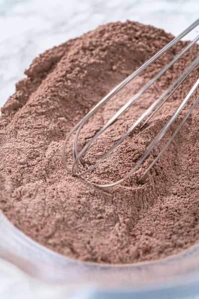 stock image Mixing ingredients in a glass mixing bowl to bake a chocolate cupcake.