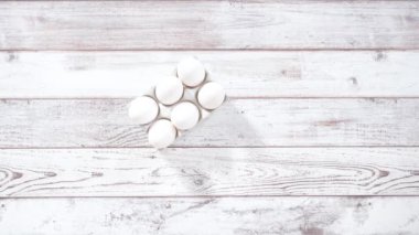 Ahşap bir masada yumurtalı ekmek hazırlamak için cam karıştırma kabındaki malzemeler..