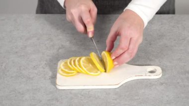 Adım adım. Beyaz tabakta organik limon dilimleri dilimliyorum..