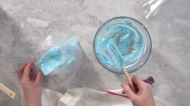 Düz yatıyordu. Adım adım. Tek boynuzlu at meringue kurabiyesi pişirmek için metal uçlu boru torbalarına krema karıştırılıyor..