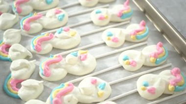 Adım adım. Taze pişmiş tek boynuzlu at kremalı kurabiyelerini süslüyor..