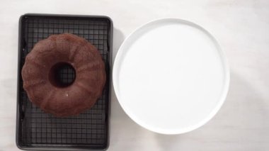 Adım adım. Düz yatıyordu. Beyaz pasta standında taze pişmiş çikolatalı kek..