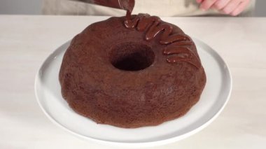 Adım adım. Beyaz pasta standında taze pişmiş çikolatalı kek..