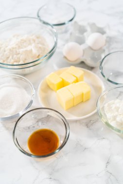 Bardaktaki ölçülü malzemeler mini vanilyalı kekler pişirmek için karıştırma kabı ve ombre pembe kremalı krema..