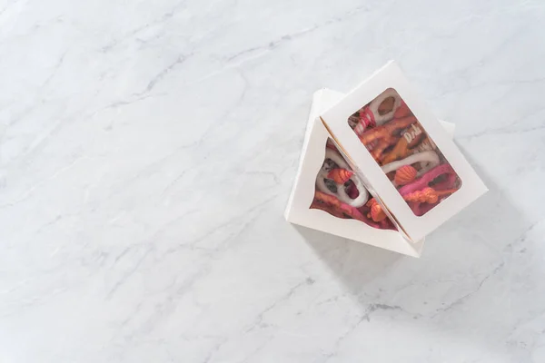 평평하게 초콜릿으로 포장된 프레첼은 조각으로 채워진 상자로 — 스톡 사진