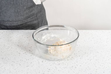 Büyük bir cam kasede ahşap bir kaşıkla karıştırılan malzemeler naan dippers pişirir..