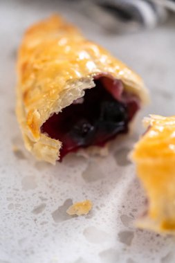 Mutfak tezgahında yaban mersinli taze pişmiş tatlı börekler..