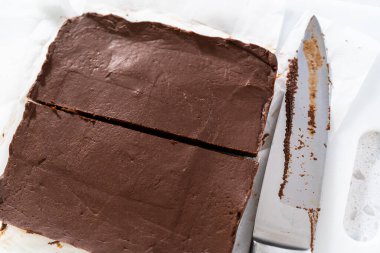 Beyaz bir kesme tahtasıyla ev yapımı şekerlemeleri küçük parçalara ayırmak..