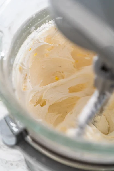 在厨房的电动搅拌器中混合配料 制成米黄色粉状奶油霜 — 图库照片