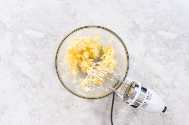 Düz yatıyordu. 4 Temmuz pastasını çikolatalı yıldızlarla karıştırmak için cam bir kasenin içindekileri karıştırıyorum..