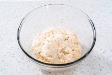 Cam bir kasede yükselen hamurlar naan dippers pişirmek için karıştırılıyor..