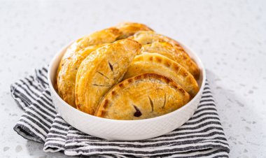 Mutfak tezgahında yaban mersinli taze pişmiş tatlı börekler..