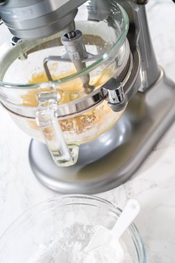 Mutfaktaki elektrikli mikserin içeriğini karıştırıp tereyağlı krema yapıyorum..