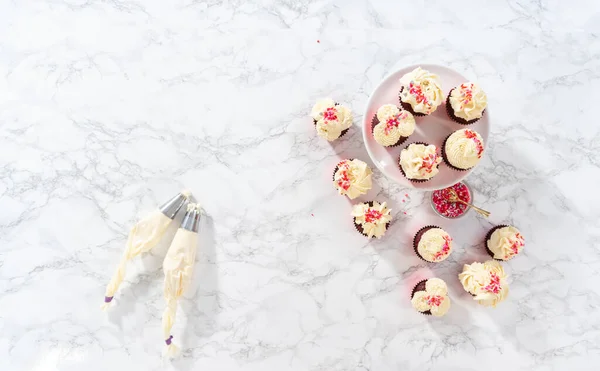 Επίπεδη Φρύξη Λευκής Σοκολάτας Πάνω Κόκκινα Βελούδινα Cupcakes Και Συμπλήρωση — Φωτογραφία Αρχείου