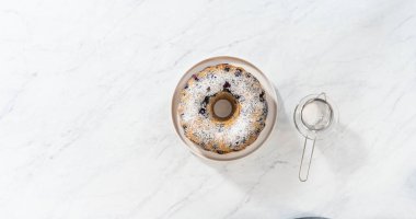 Düz yatıyordu. Taze fırınlanmış limonlu yaban mersinli kekin tozunu alıyorum..