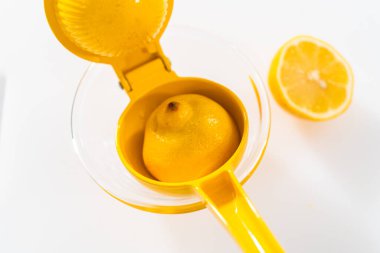 Beyaz bir kesme tahtasının üzerinde taze limon zıp zıp..