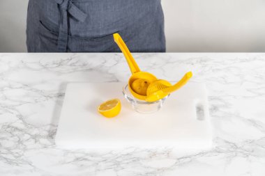 Beyaz bir kesme tahtasının üzerinde taze limon zıp zıp..