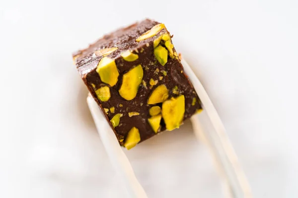 Holding Homemade Chocolate Pistachio Fudge Square Piece Kitchen Tongs — Stock Photo, Image