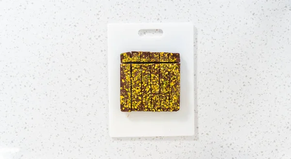 Deitado Corte Chocolate Pistache Fudge Com Uma Grande Faca Cozinha — Fotografia de Stock