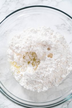 Küçük Paskalya ekmeği için limon jölesi yapmak için karışımı büyük bir karıştırıcı ile karıştırıyorum..