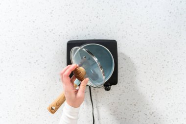 Düz yatıyordu. Şam fıstıklı çikolata hazırlamak için tencerede kaynar su..