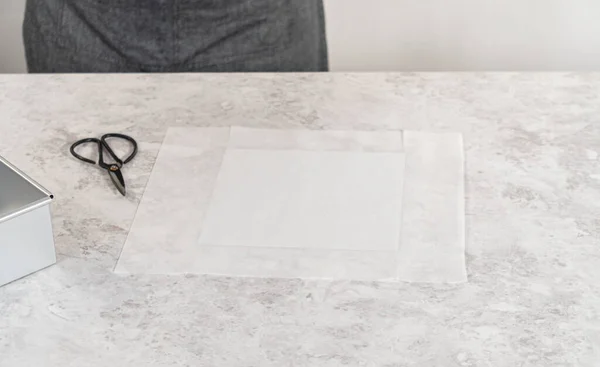 stock image Lining square cheesecake pan with parchment paper sheet to prepare eggnog fudge.