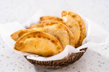 Mutfak tezgahındaki tavada taze pişmiş vişneli börek var..