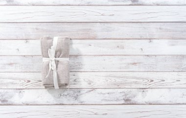 Düz yatıyordu. Beyaz ahşap bir masada yeni bir peçete yığını..