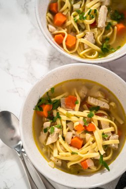 Beyaz seramik çorba kaselerinde kluski şehriyeli tavuk çorbası servis ediyorum..