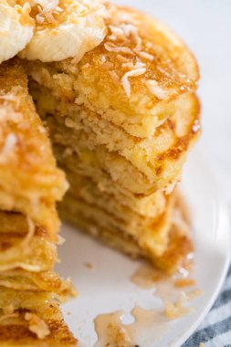 Dilimlenmiş muz ve kızarmış hindistancevizi ile süslenmiş taze hindistan cevizli krep yemek..