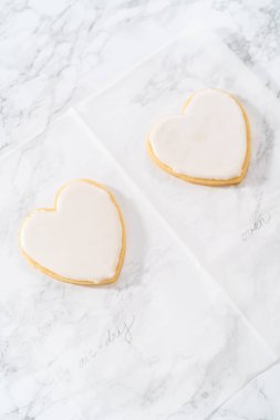 Sevgililer Günü için pembe ve beyaz kraliyet kremalı kalp şeklinde kurabiyeler..