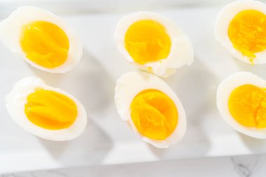 Beyaz servis tabağında dilimlenmiş haşlanmış yumurta..