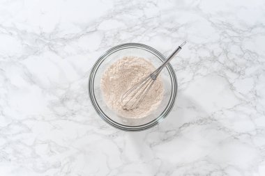 Düz yatıyordu. Yumuşak yulaf ezmesi üzümlü cevizli kurabiye pişirmek için büyük bir bardakta kuru malzemeler karıştırıyorum..