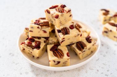 Beyaz seramik tabakta ev yapımı beyaz çikolatalı fındıklı şekerleme parçaları..