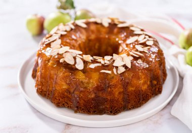 Beyaz tabakta karamel jöleli taze pişmiş elmalı kek..