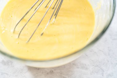 Manzarayı kapat. Manzarayı kapat. Fünyeli kek pişirmek için karıştırma kabındaki malzemeleri karıştırıyorum..