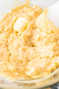 Çikolata parçacıkları ve diğer malzemeleri kaynayan suyun üzerinde karıştırarak mısır şekeri hazırlamak..