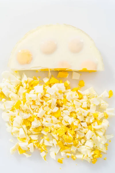 Beyaz Bir Kesme Tahtasının Üzerinde Haşlanmış Yumurta Kesiyor — Stok fotoğraf