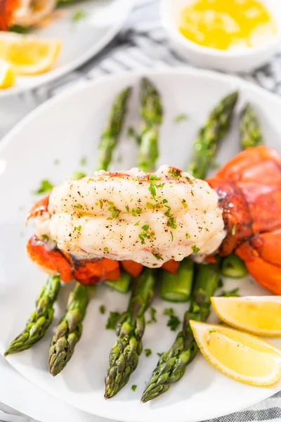 Sering Garlic Lobster Tails Steamed Asparagus Lemon Wedges White Plate — Stockfoto
