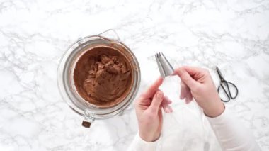 Zaman aşımı. Düz yatıyordu. Çukulata renginde ganache kreması, metal uçlu bir torbaya konuyor..