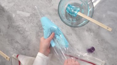 Düz yatıyordu. Adım adım. Tek boynuzlu at meringue kurabiyesi pişirmek için metal uçlu boru torbalarına krema karıştırılıyor..