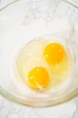 Büyük bir bardaktaki malzemeleri karıştırarak naneli çikolatalı kekler pişiriyorum..