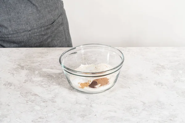 大きなガラスのボウルに手泡立て器で乾燥成分を混合し クリームチーズの霜でニンジン束ケーキを焼くために混合 — ストック写真
