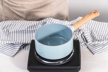 Elektrikli tavanın üzerine küçük bir tencereyle şeker şurubu hazırlıyorum..
