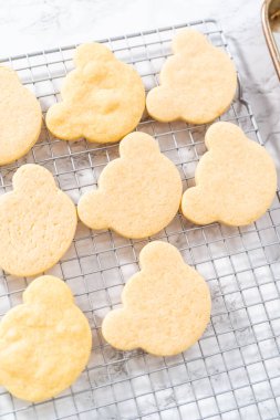 Cooling panda-shaped shortbread cookies on a cooling rack at the kitchen counter.