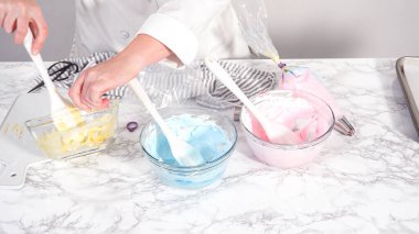 Adım adım. Tek boynuzlu at kurabiyesi pişirmek için besin boyasını kremaya karıştırıyorum..