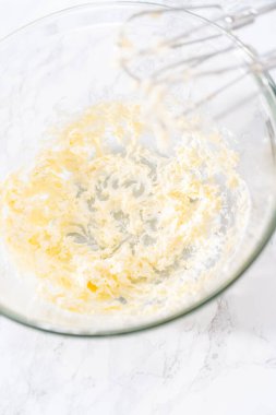 Krem peynirli çiseleme sosu hazırlamak için büyük bir bardakta karıştırma malzemesi..