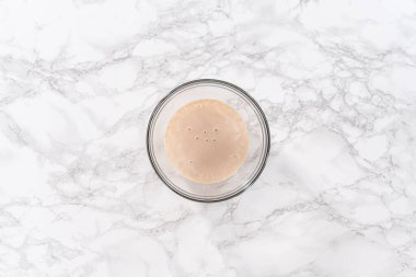 Düz yatıyordu. Ev yapımı brioche çörekleri pişirmek için malzemeleri karıştırıyorum..